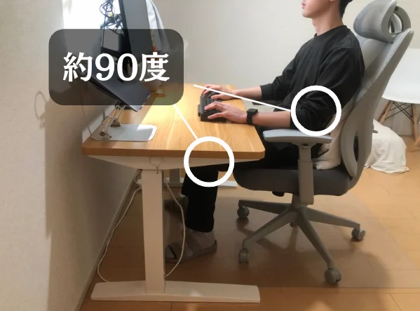 デスク使用時の正しい姿勢。肘が90度、足裏が床につく様子