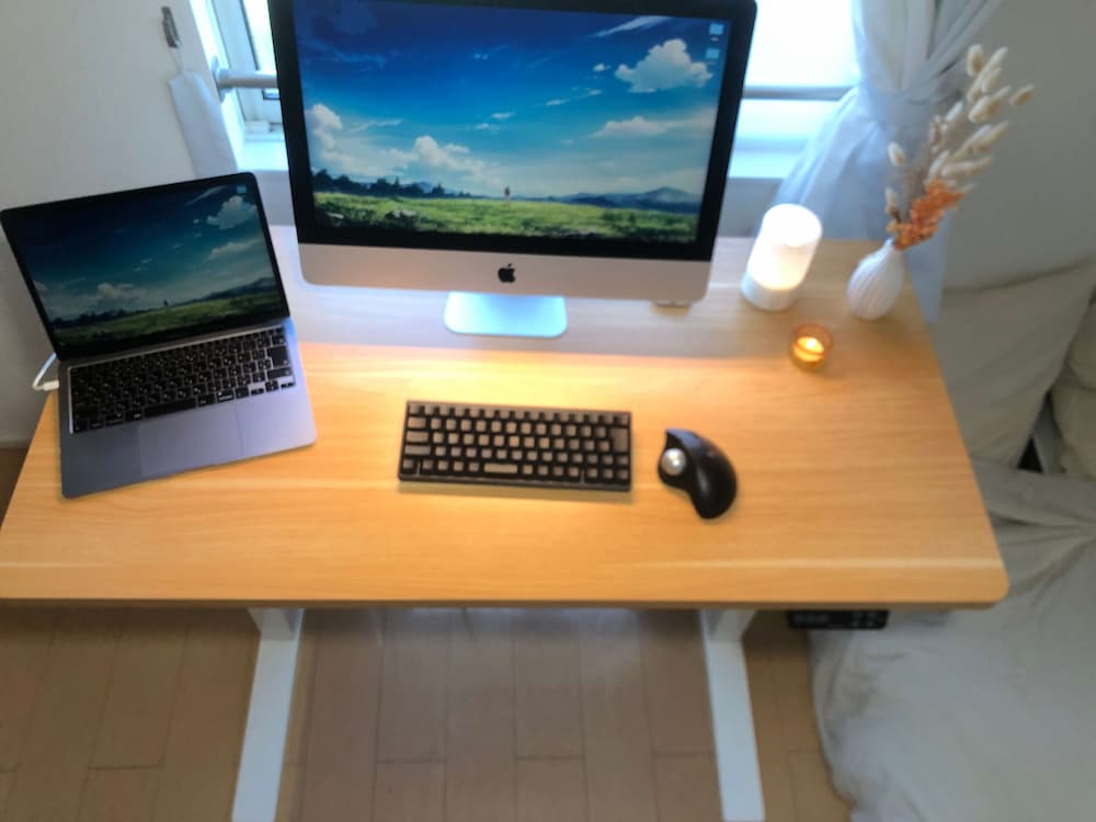 FlexiSpot E7Hの脚部構造。頑丈なエ字型フレームと左右に配置されたimacとmacbookのアップ写真。